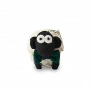Knitted wool sheep keyring wearing a green tartan bowtie, on a plain grey background.