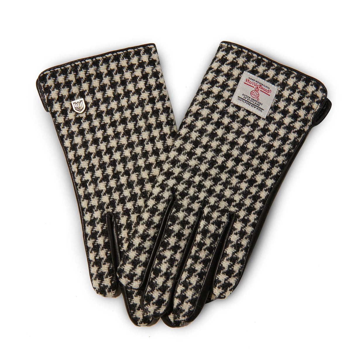 Pair of ladies black dogtooth Harris Tweed® gloves with leather trim, touch screen design, handwoven fabric from Scotland, front view.