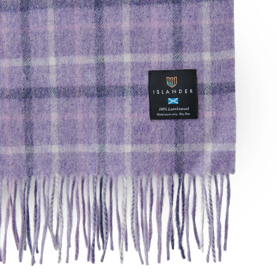 Lilac tartan lambswool scarf showing the woven Islander label