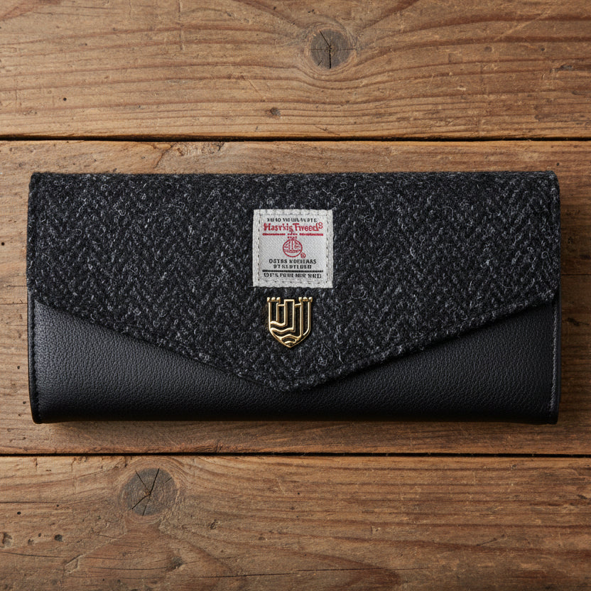 Harris Tweed clasp purse in black herringbone on wooden surface