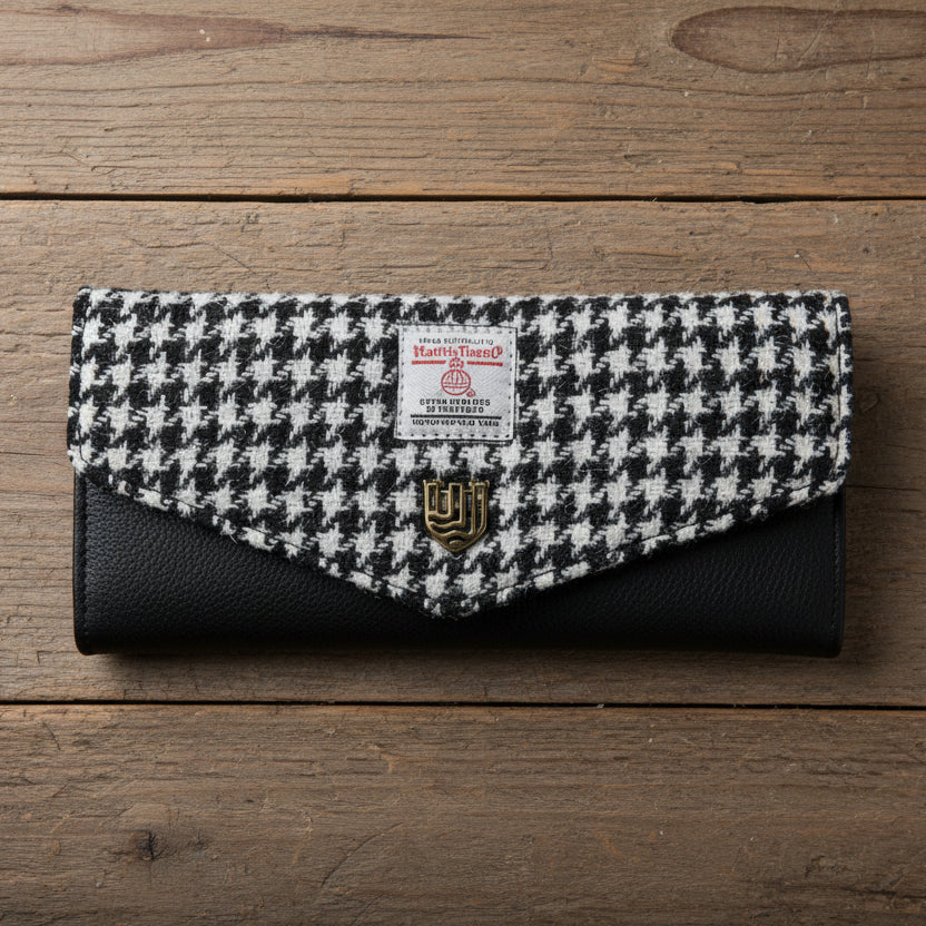 Black and white dogtooth Harris Tweed clasp purse on wooden surface