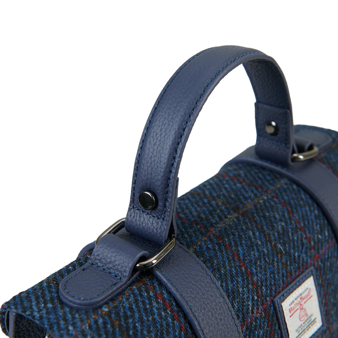 Close-up of navy leather handle and Harris Tweed over-check fabric detail.