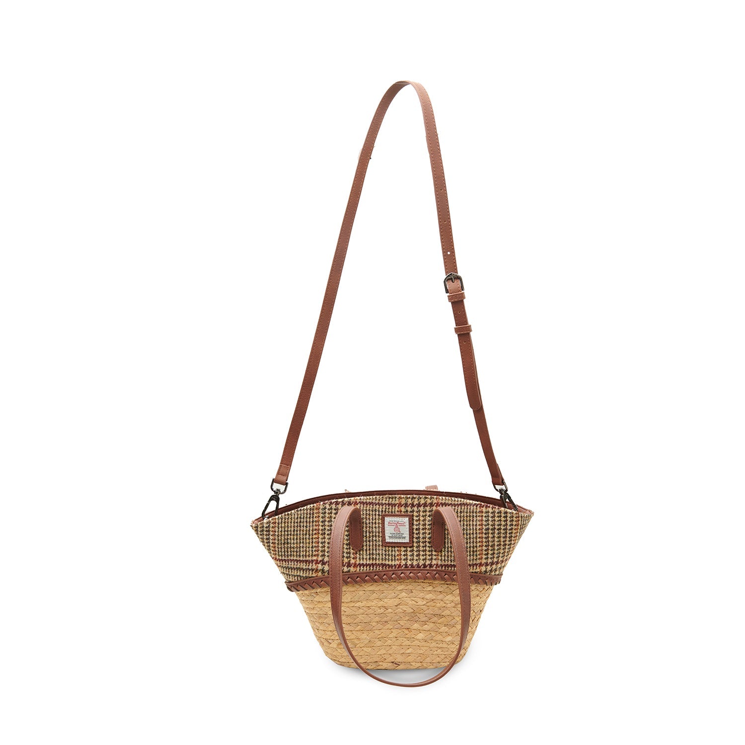Beige dogtooth basket bag worn crossbody with the strap fitted