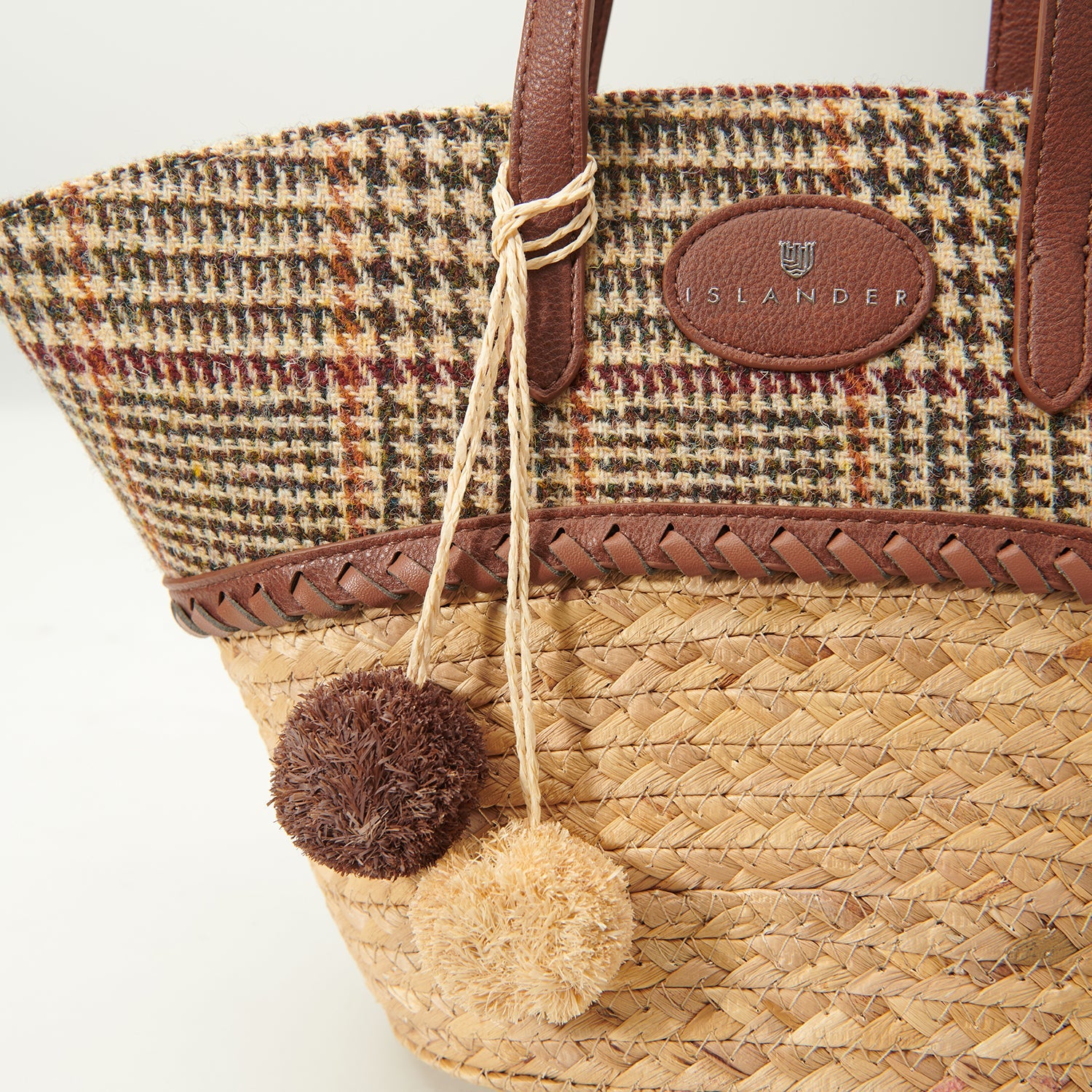 Detail of the woven straw, tweed lid and two wool pom pom charms