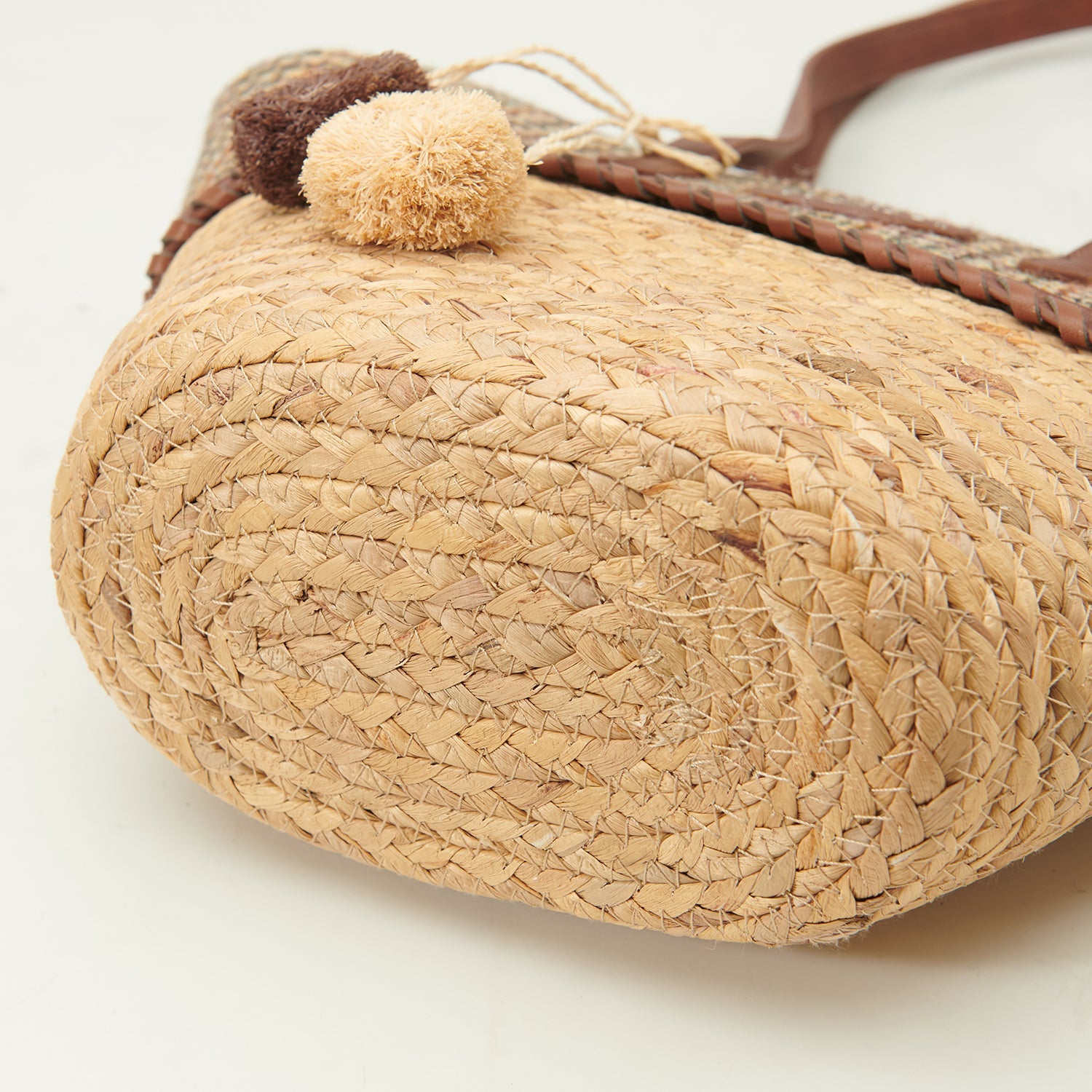 Underside of the basket bag showing the tightly woven straw base