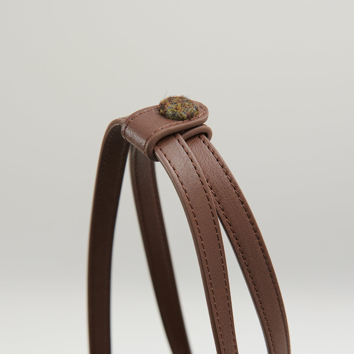 Leather handle button detail on chestnut tartan Harris Tweed bucket bag