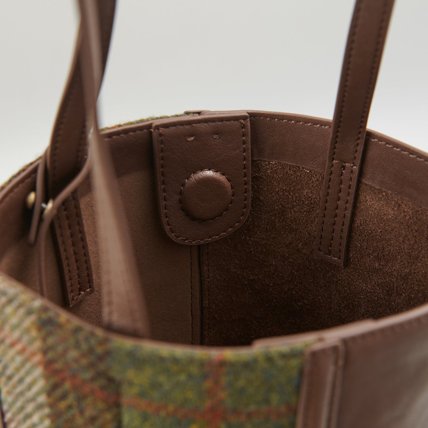 Interior leather detail of chestnut tartan Harris Tweed bucket bag