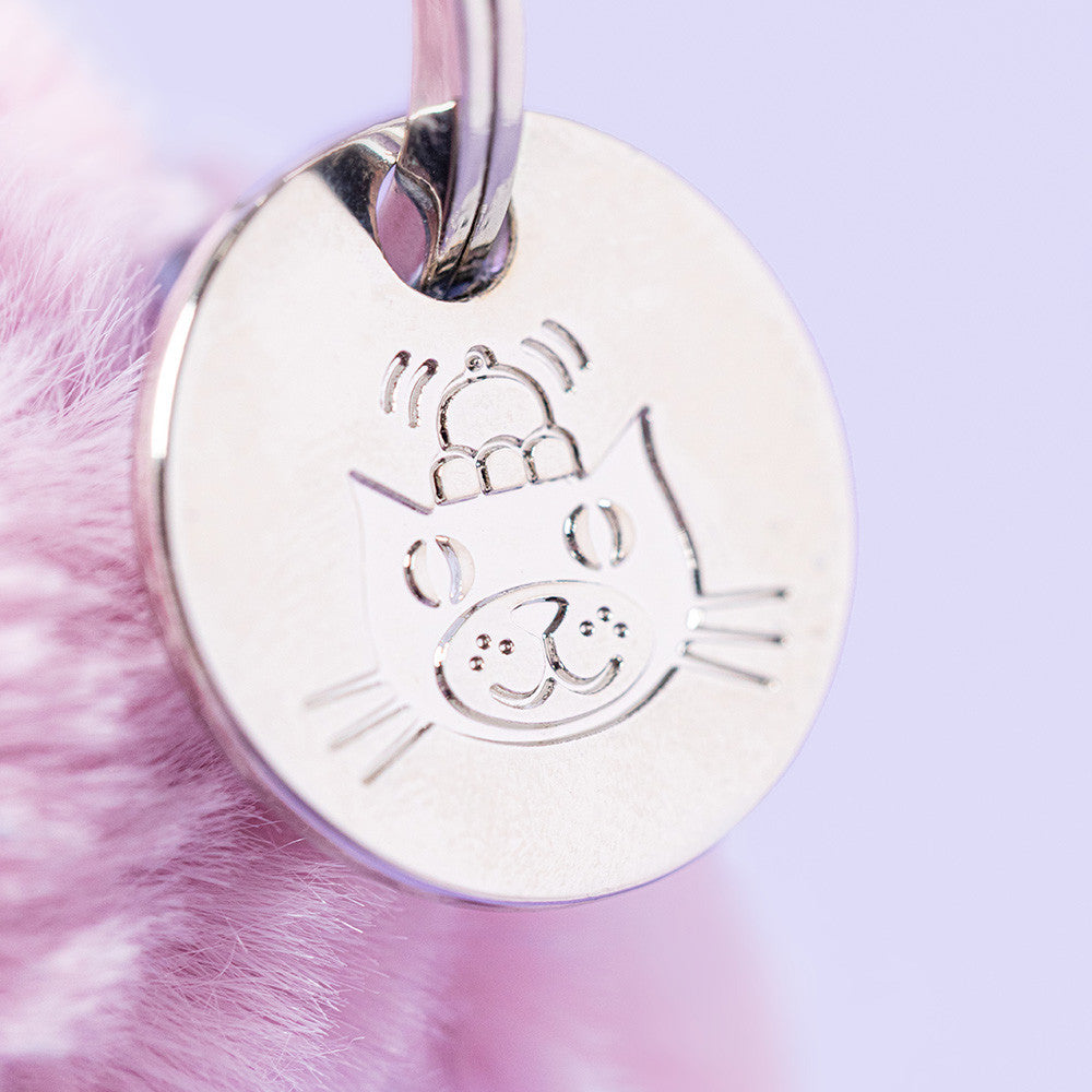 Close-up of engraved Jellycat disc on Thistlepop bunny charm, lilac background
