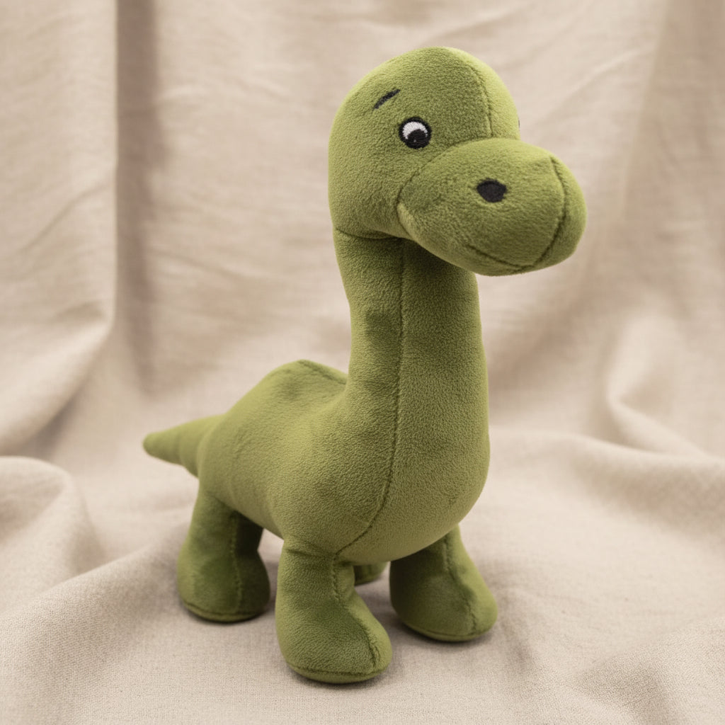 Nessie stuffed plush toy showing embroidered eyes and soft green fabric, white background