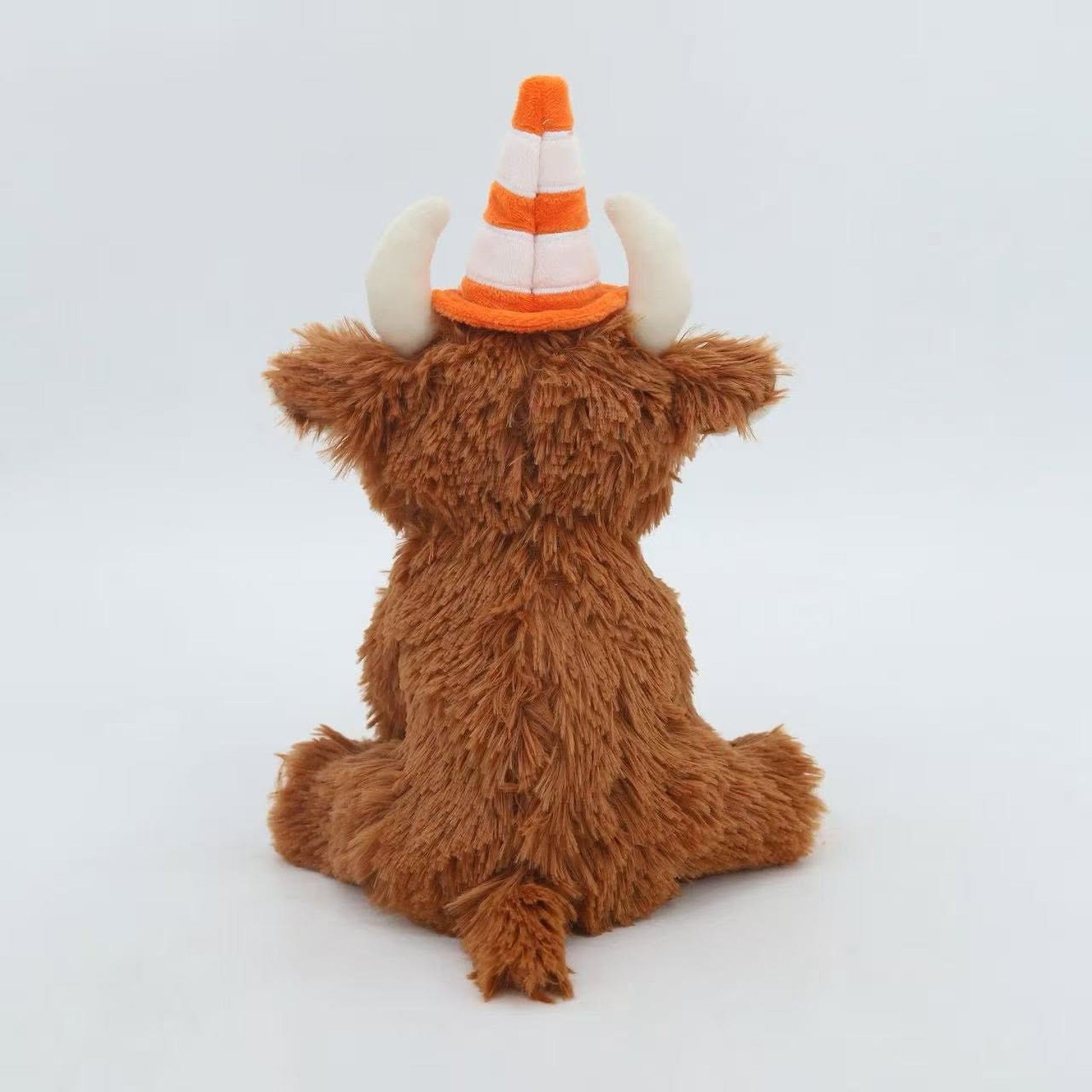 Back view of the traffic cone Highland cow plush showing shaggy brown fur