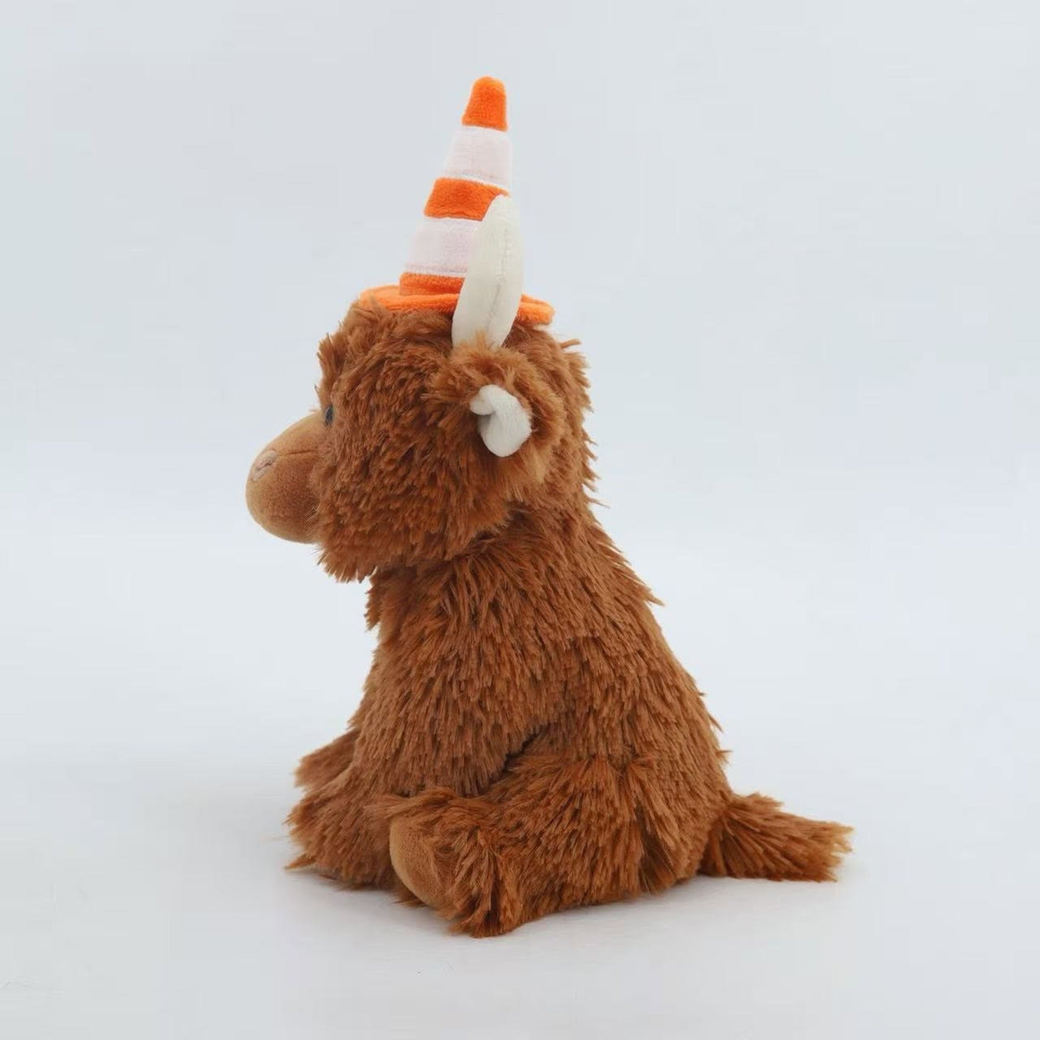 Side view of the traffic cone Highland cow plush toy and its cone hat