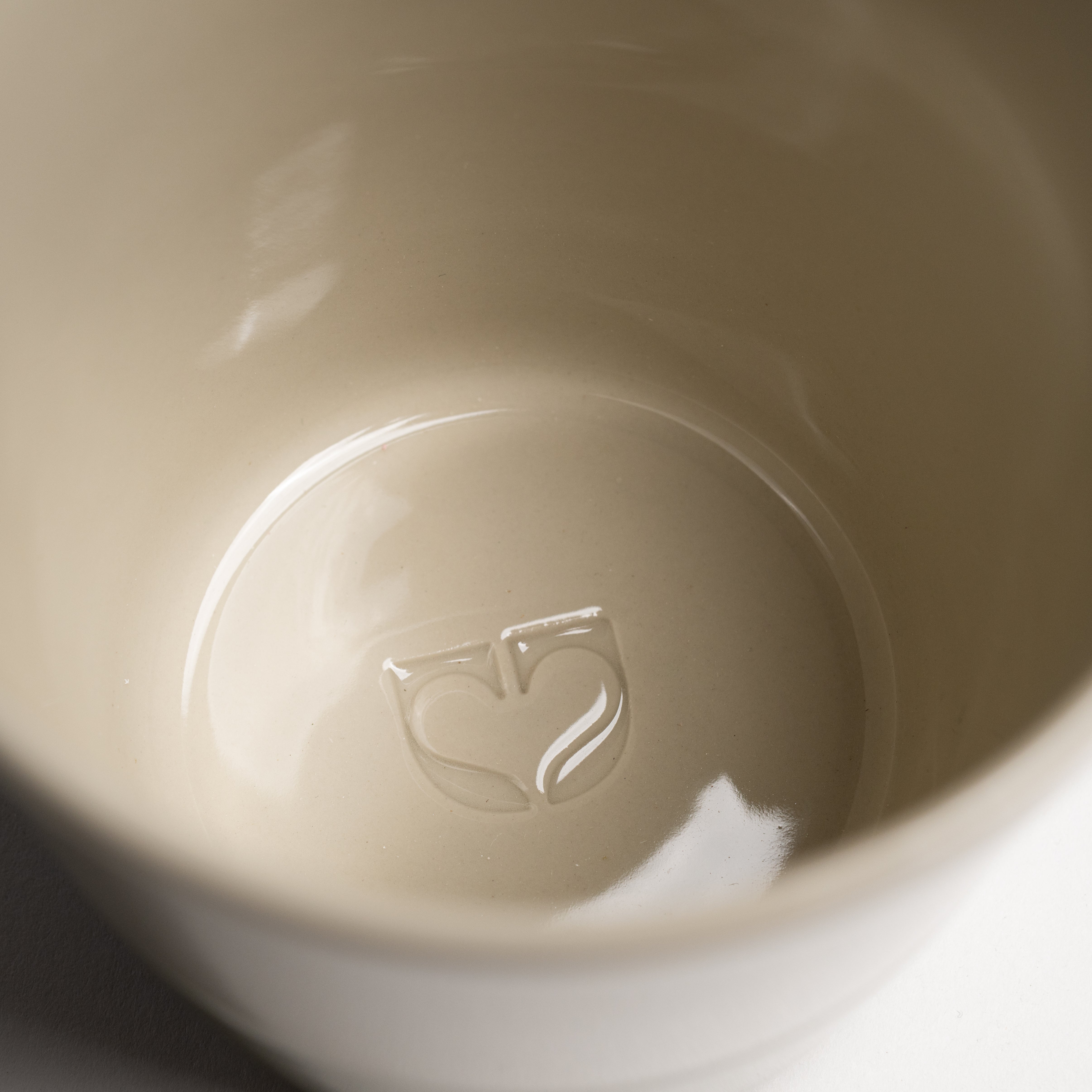 Close up of the Kindred icon embossed inside a Sorrel beaker base