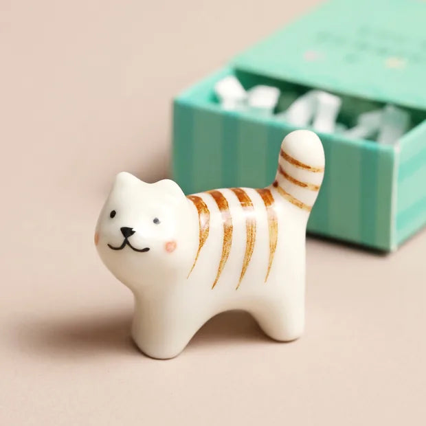 Close-up of ceramic tabby cat with orange stripes and smiling face