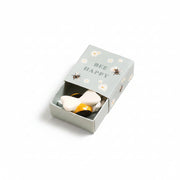 Ceramic bee inside open sage green matchbox with daisy and bee design on cream background