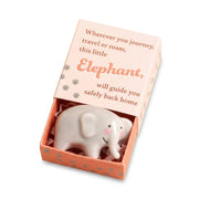 Tiny ceramic elephant token in its matchbox on white