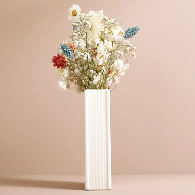 Pages side of ceramic book vase showing ridged detail with dried flowers