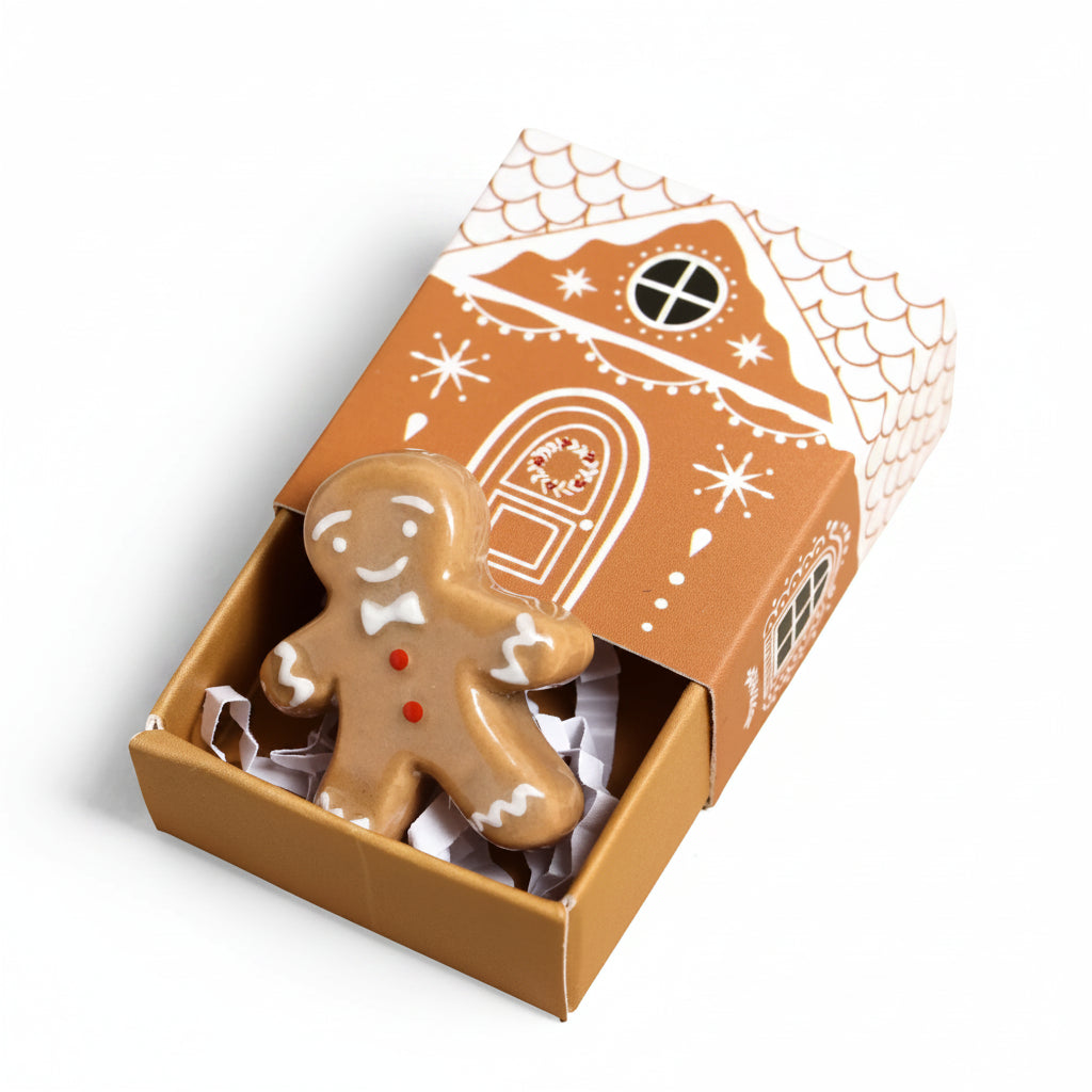 Ceramic gingerbread man token in an open gingerbread house matchbox