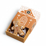 Ceramic gingerbread man token in an open gingerbread house matchbox