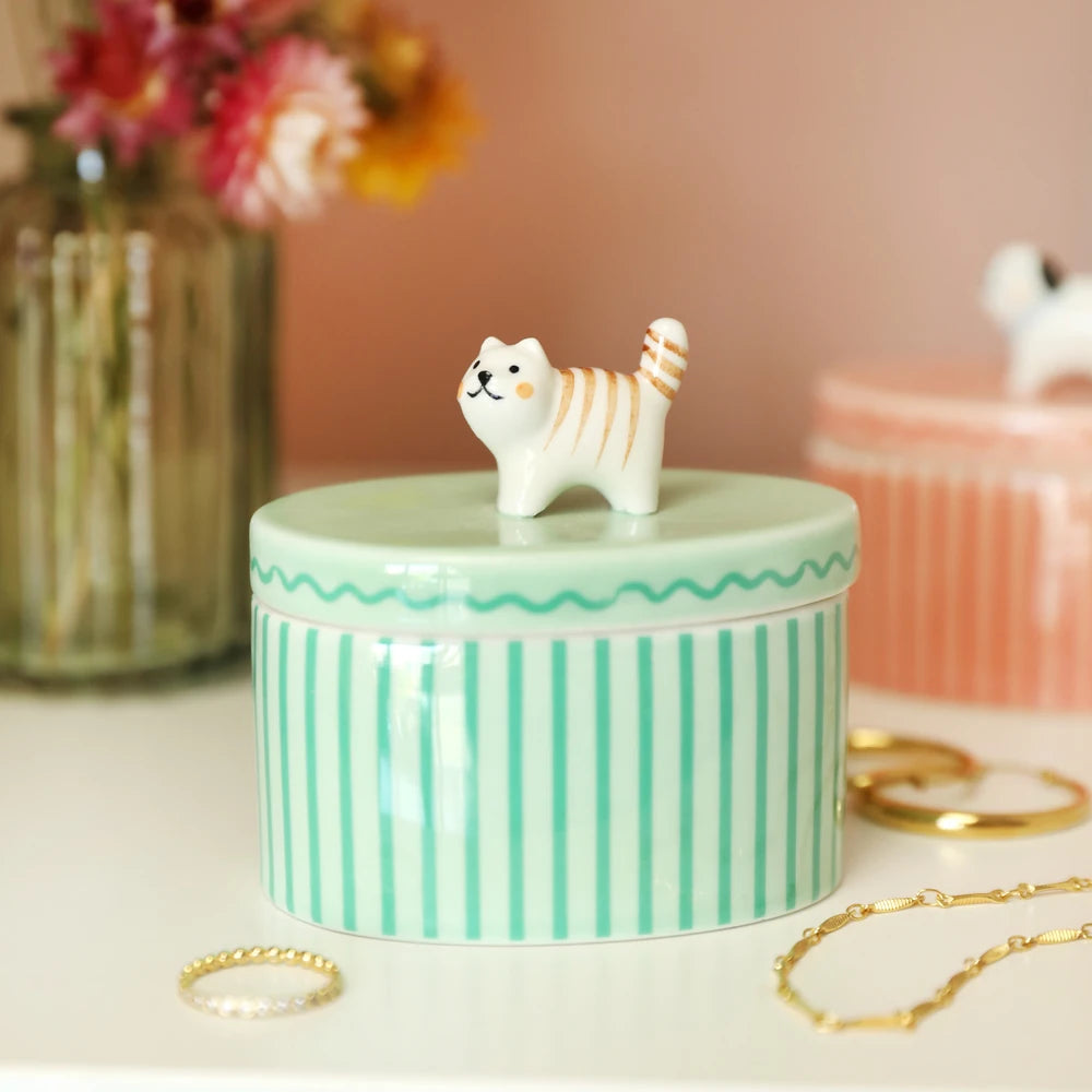 Cat trinket pot styled on a dresser beside dried flowers and jewellery