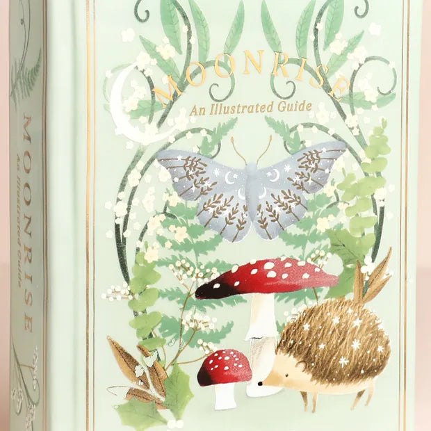 Close-up detail of moth, toadstool, and hedgehog illustration on vase
