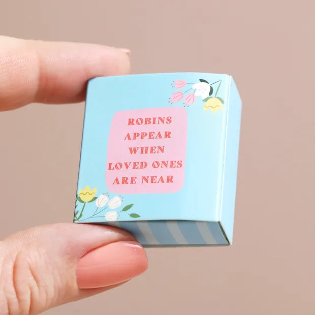 Closed blue matchbox showing keepsake message held in fingers