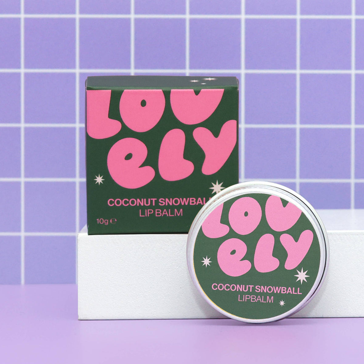 Coconut Snowball lip balm tin and box on a lilac grid