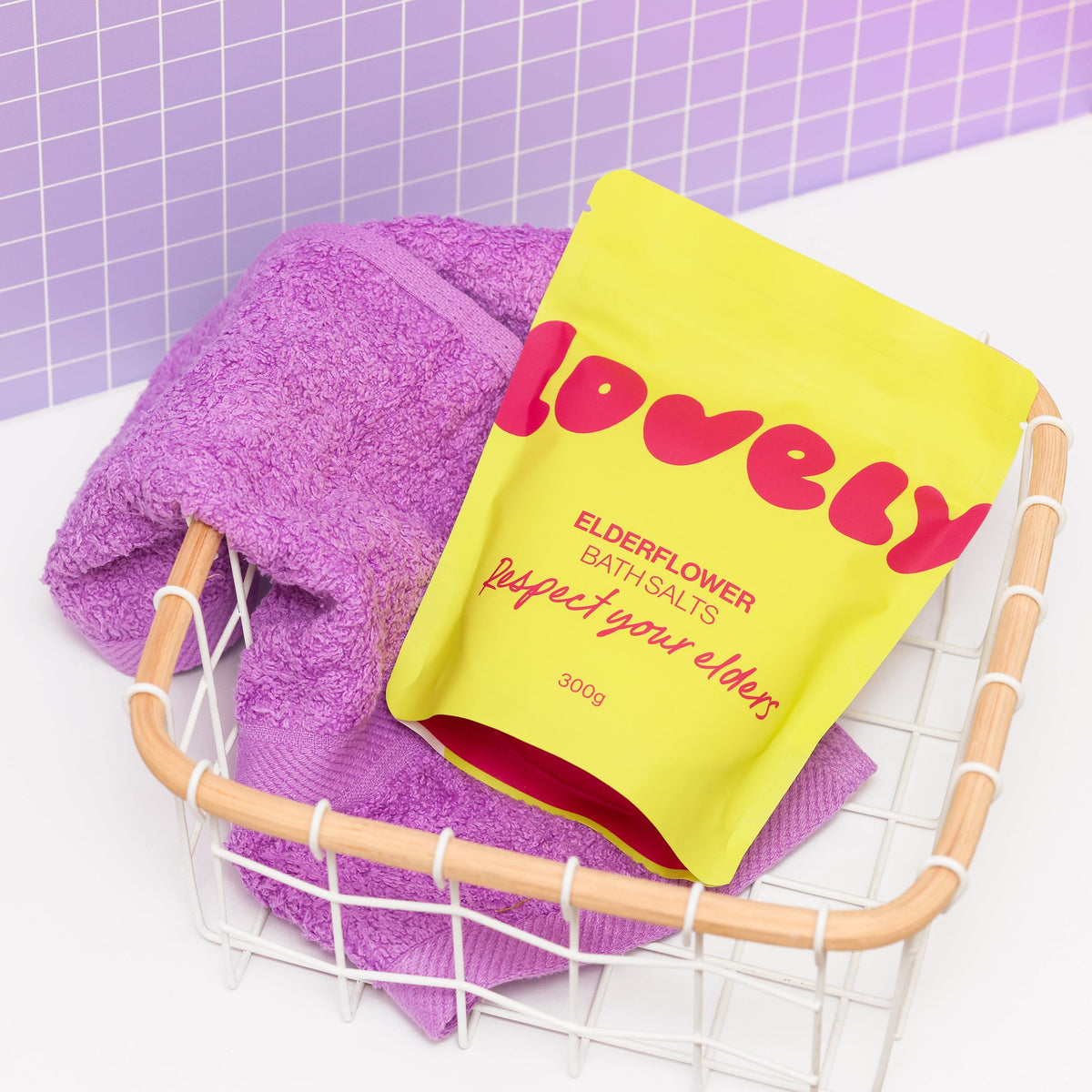 Elderflower bath salts in a wire basket with a towel