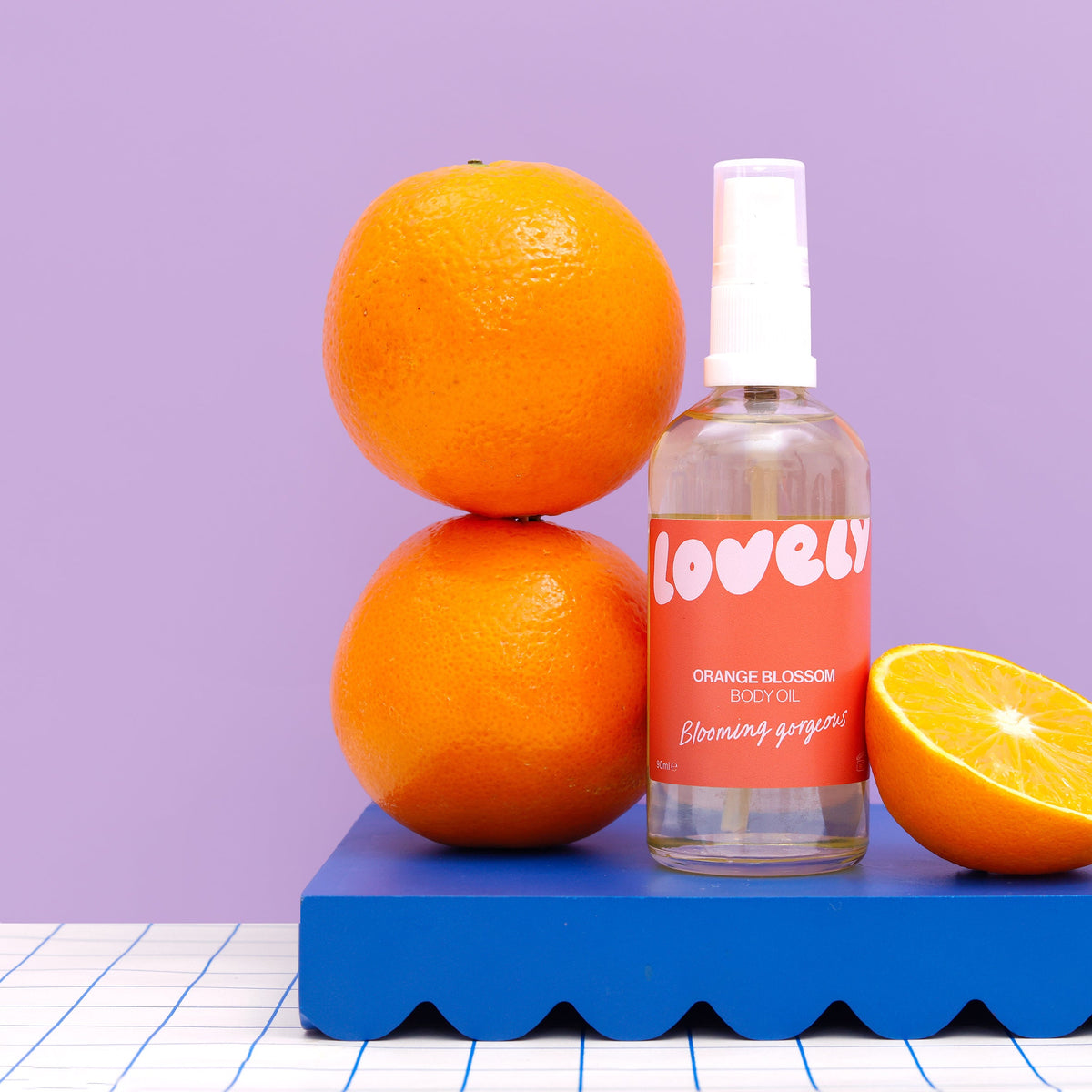 Orange Blossom body oil beside stacked oranges