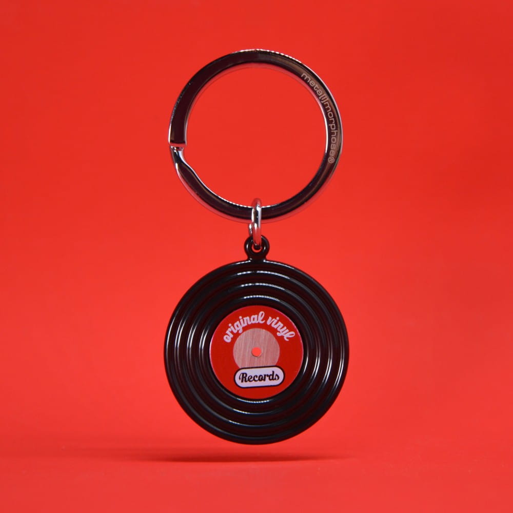 Vinyl record keyring shown front on against a red background