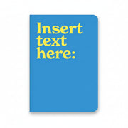 Insert Text Here A5 notebook with blue cover and white lettering
