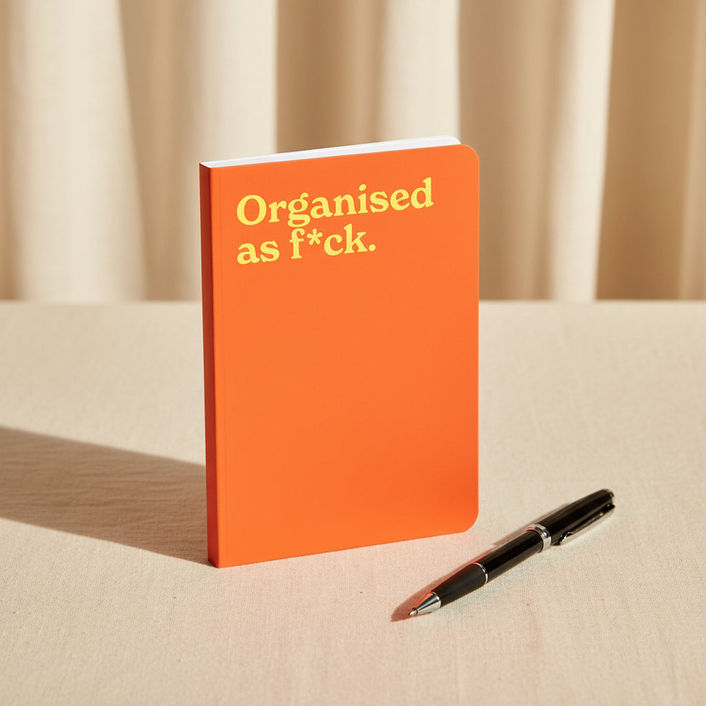 Organised as F*ck neon A5 notebook shown flat on a white background