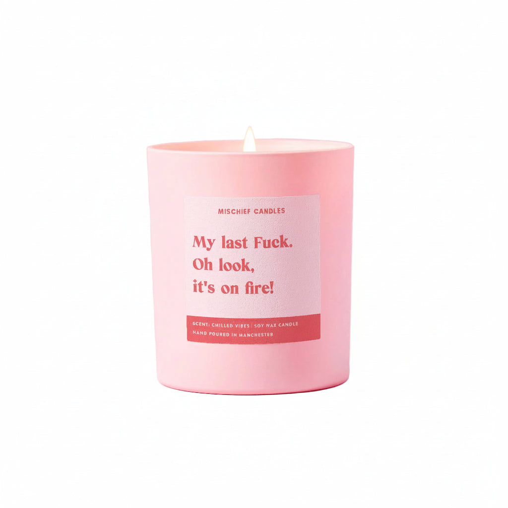 Pink candle with a humorous label on a pink background