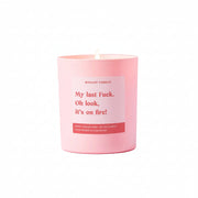 Pink candle with a humorous label on a pink background