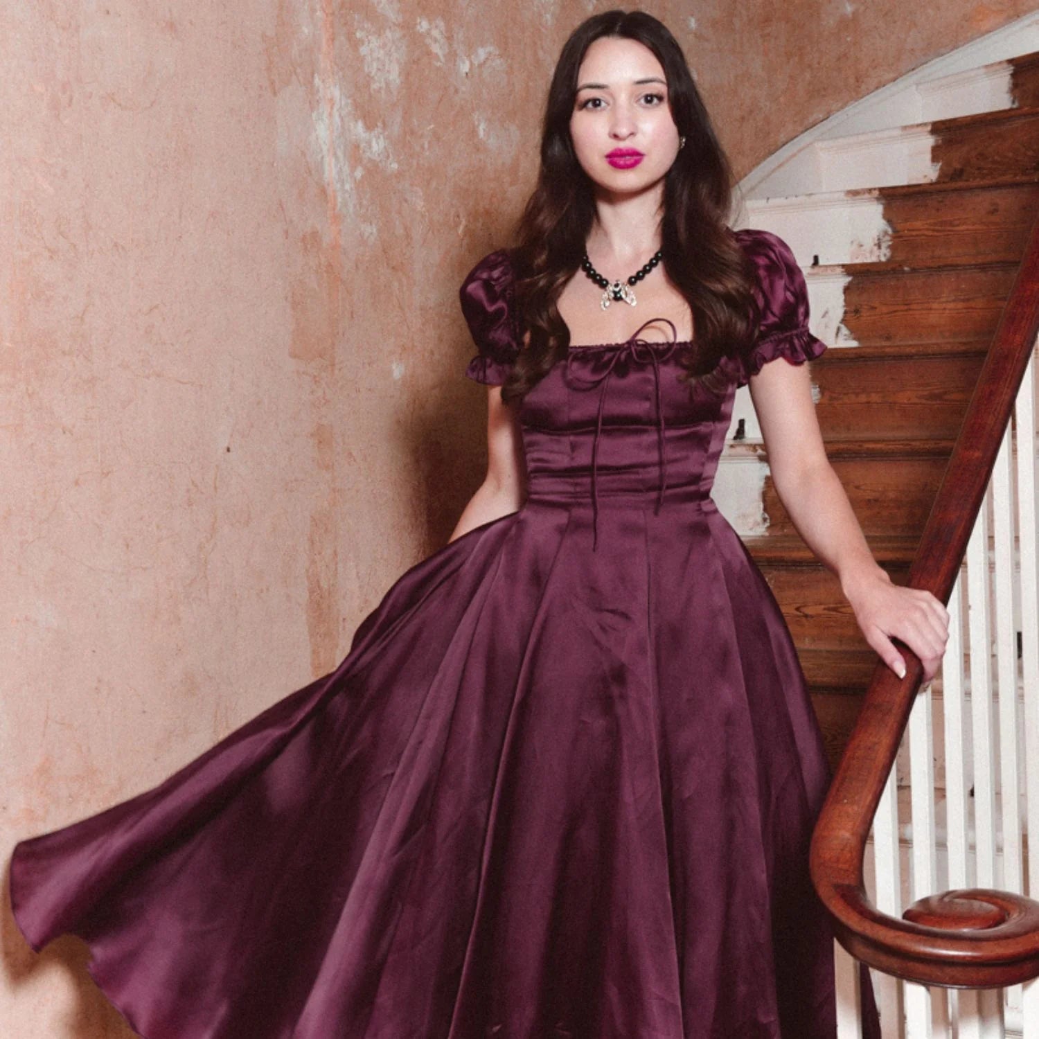 Full-length shot of model in plum satin dress wearing Bill Skinner Moth Statement Necklace, styled for an elegant evening look.