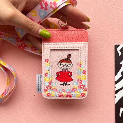 Hand holding Moomin Little My Lanyard showing reverse ID window design with floral border.
