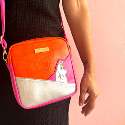 Moomin Snorkmaiden Silver Mini Bag in pink, orange and silver vegan leather worn crossbody.
