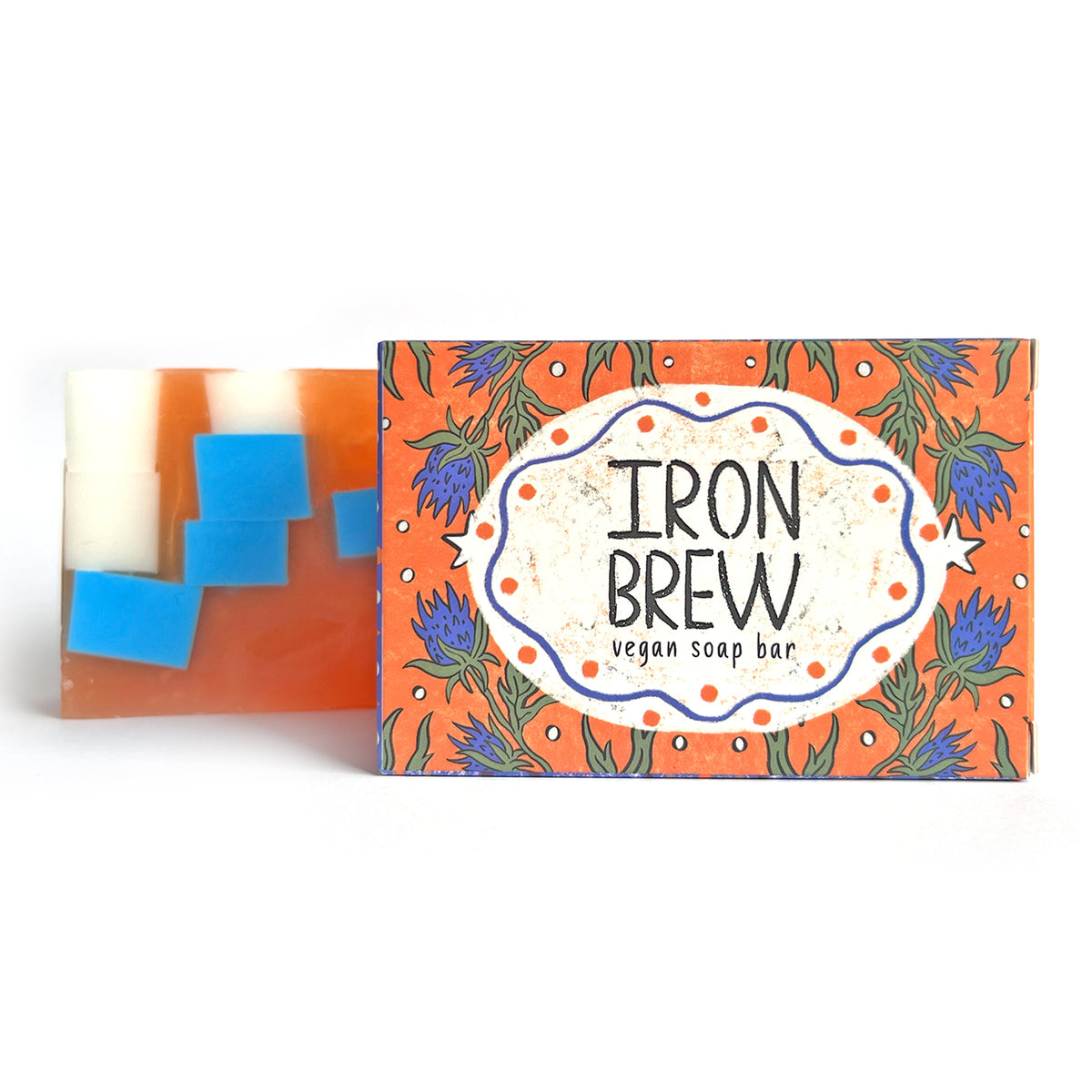 Iron Brew vegan soap bar with orange thistle-patterned box on a white background