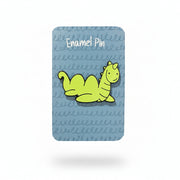 Nessie enamel pin on its illustrated backing card, held in a hand