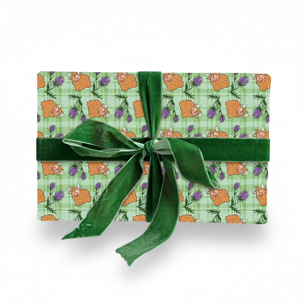 Tartan Highland cow wrapping paper on a gift tied with green ribbon
