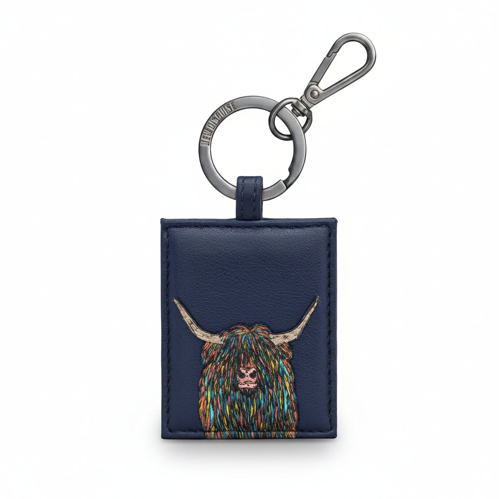 Navy leather key fob with a colorful highland cow design on a white background