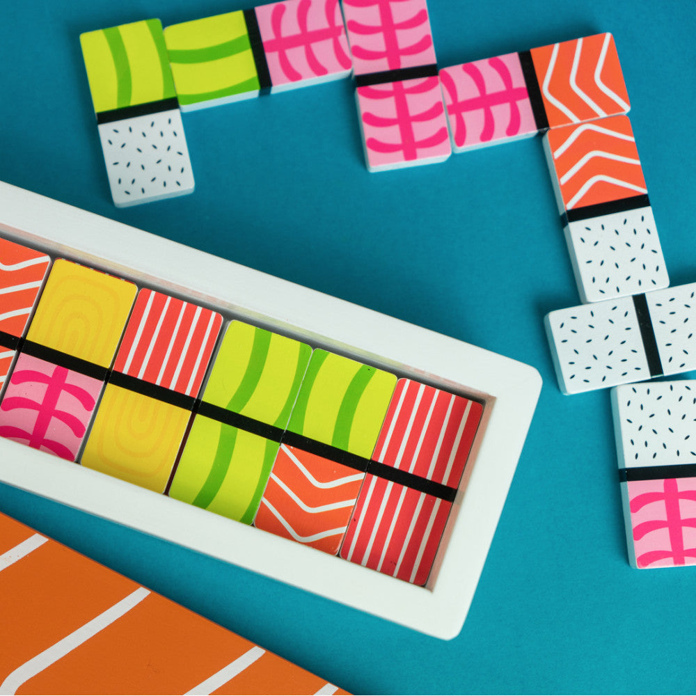 Colourful sushi domino pieces scattered on blue background