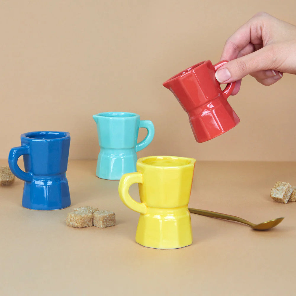 Four multicolour ceramic espresso cups with hand holding red cup