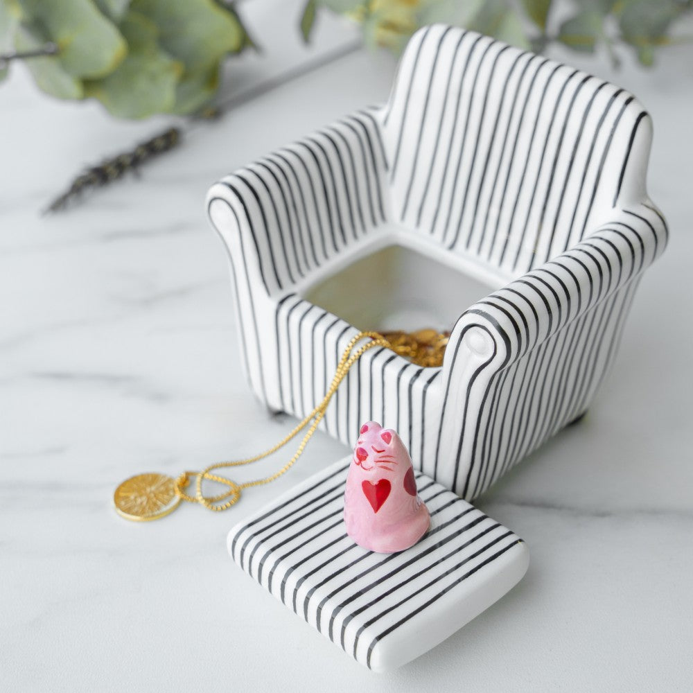 Open trinket box showing pink cat on striped sofa with jewellery