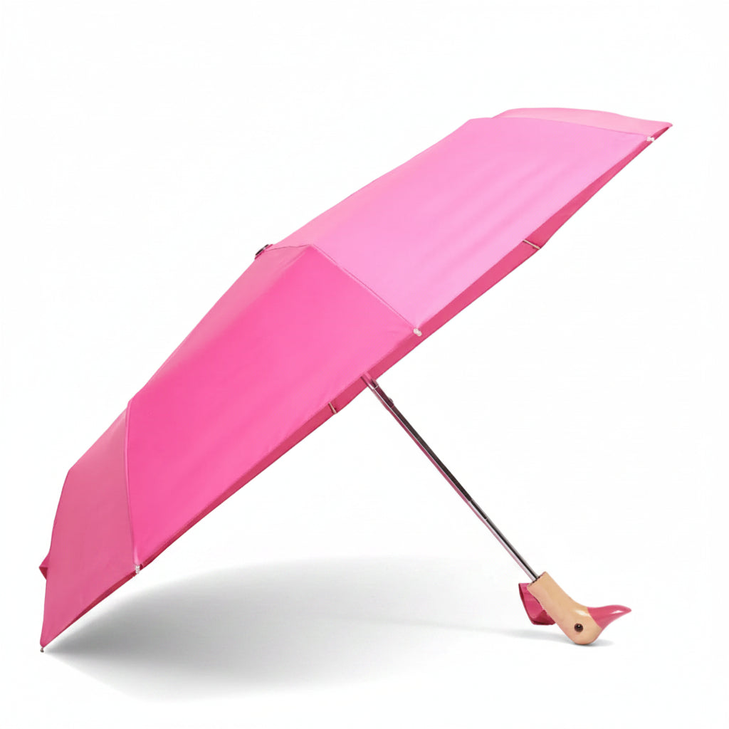 Bonbon pink compact duck umbrella open resting on light grey background