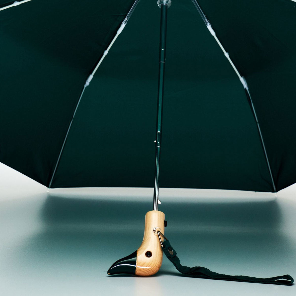 Forest green duck umbrella open from underneath showing ribs and handle