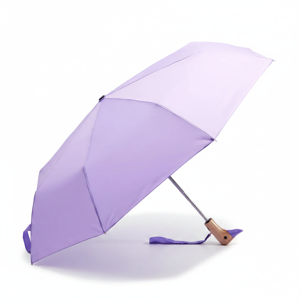 Macaron lilac compact duck umbrella open resting on light background