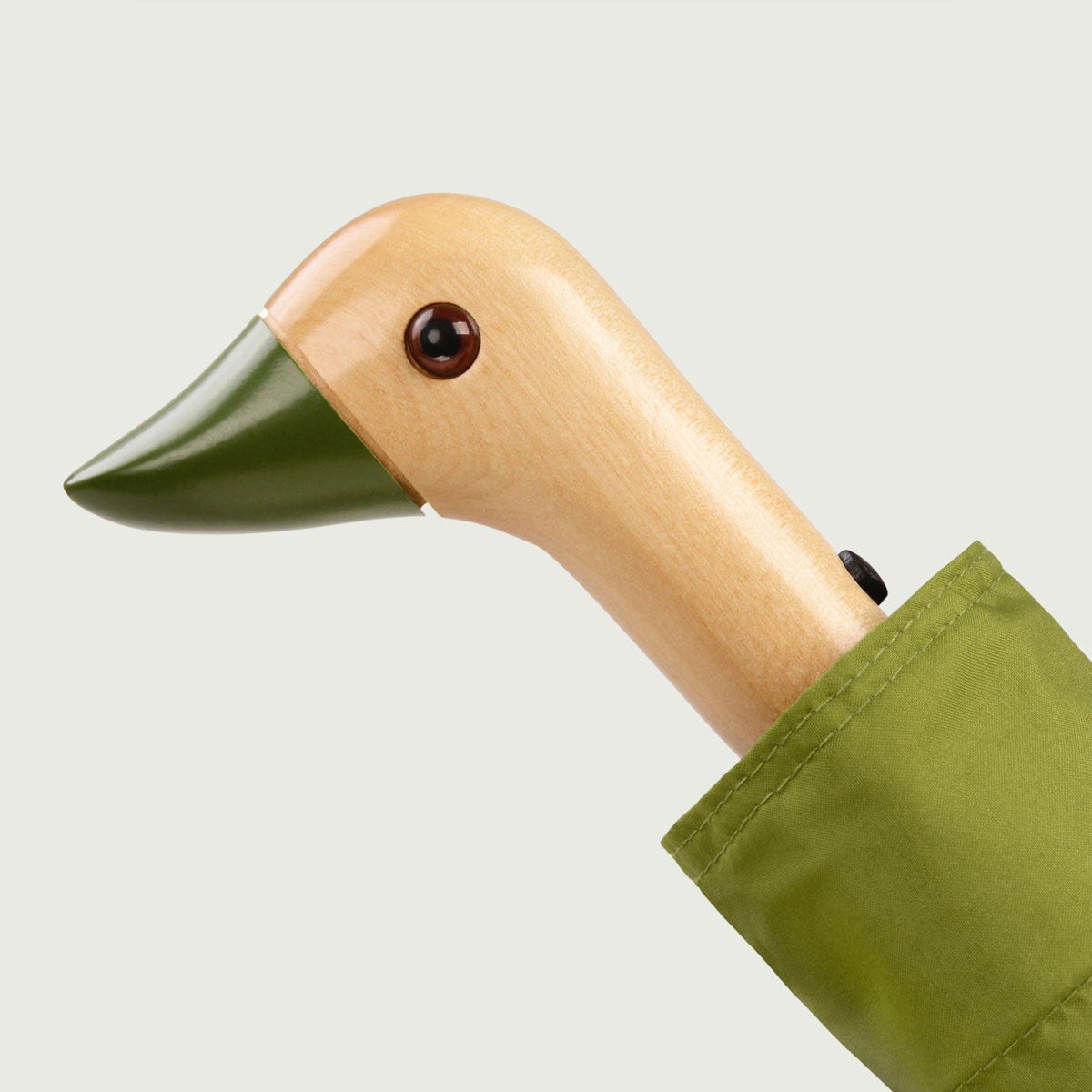 Close-up of wooden duck head handle with olive-green beak on white background