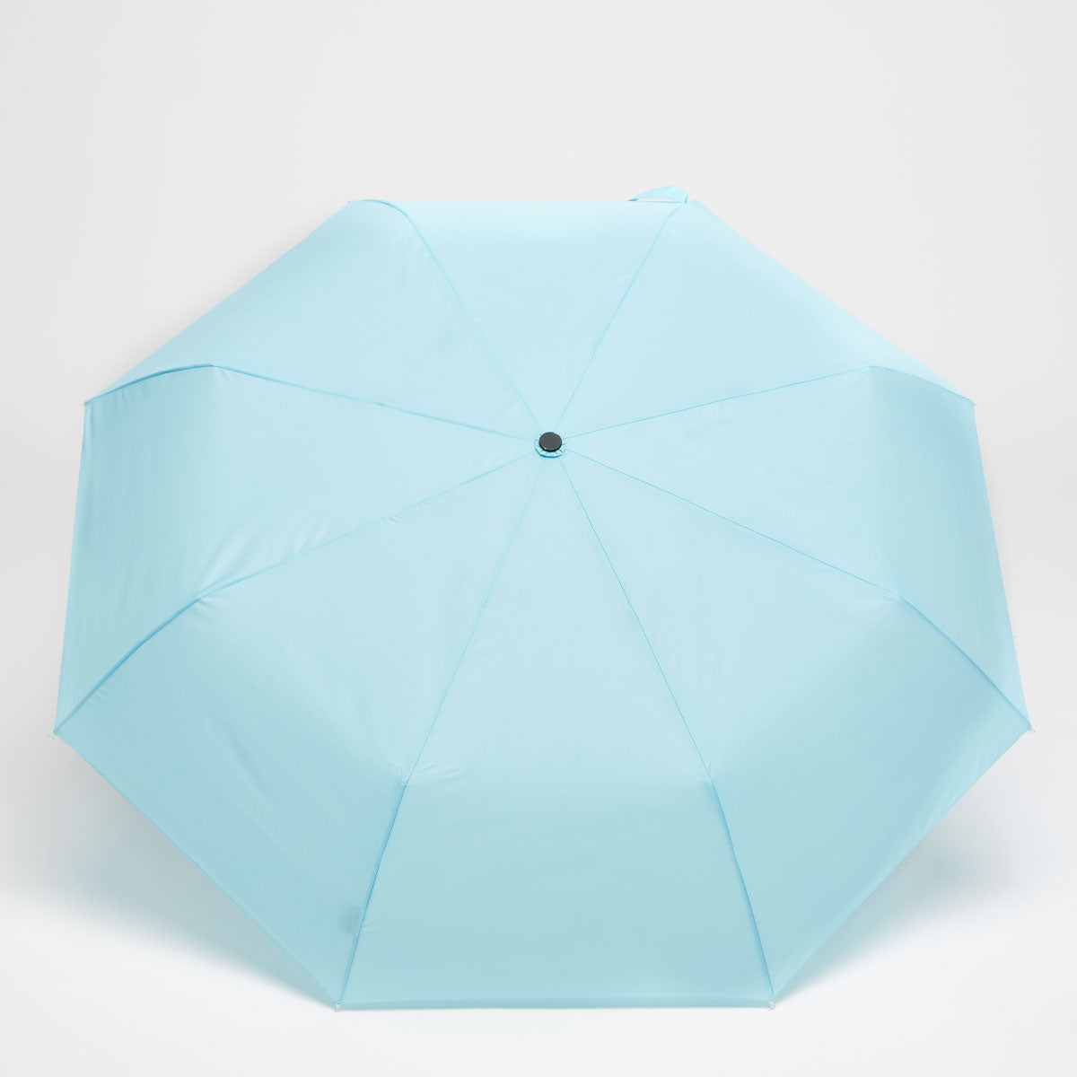 Top-down view of open sky blue duck umbrella canopy on grey background