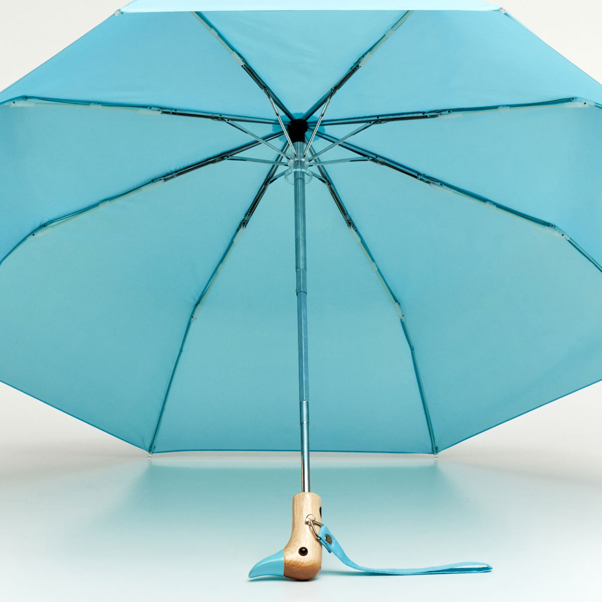 Blue duck umbrella open from underneath showing ribs and wooden handle