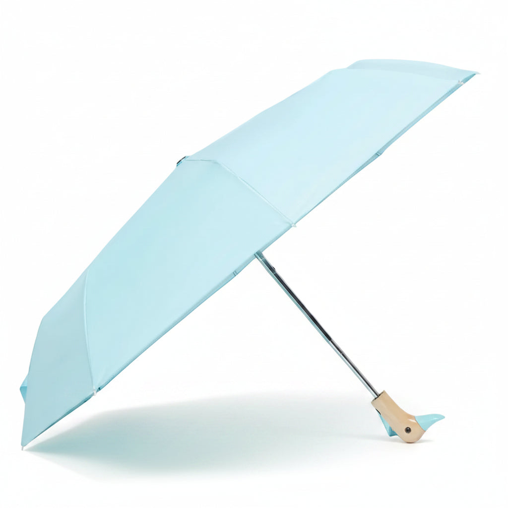 Popsicle blue compact duck umbrella open resting on light background